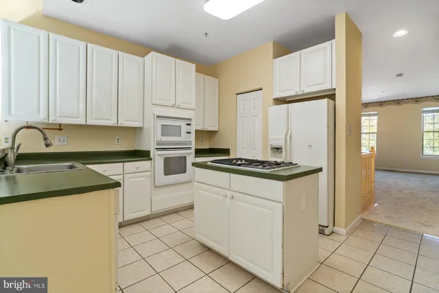 a kitchen with white cabinets and white appliances