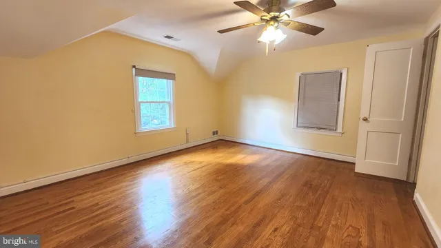a view of a room with wooden floor and a ceiling fan