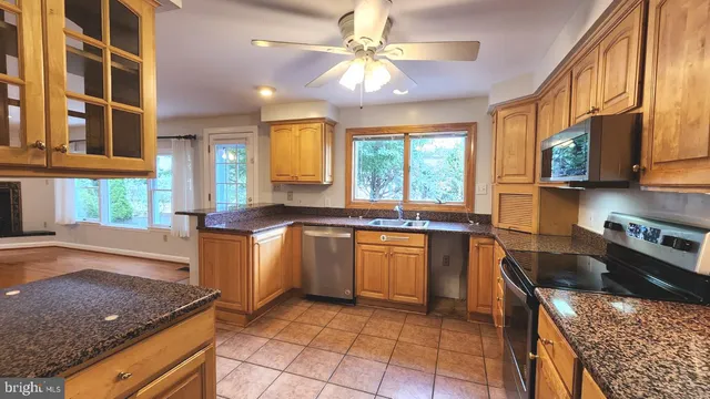 a kitchen with stainless steel appliances granite countertop a sink stove and cabinets