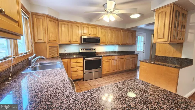 a large kitchen with stainless steel appliances granite countertop a stove a sink dishwasher a refrigerator and dishwasher with wooden floor