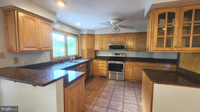 a kitchen with stainless steel appliances granite countertop a stove a sink and a microwave
