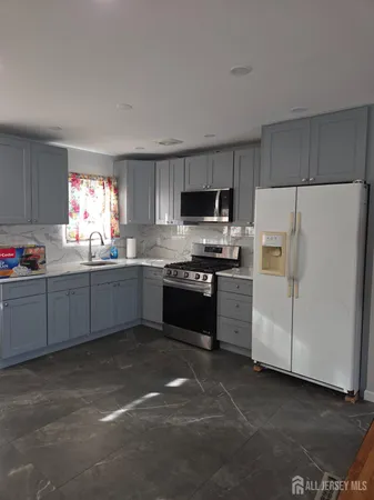 a kitchen with granite countertop a stove and refrigerator