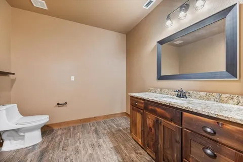 a bathroom with a granite countertop toilet sink and mirror