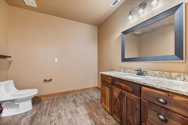 a bathroom with a granite countertop toilet sink and mirror