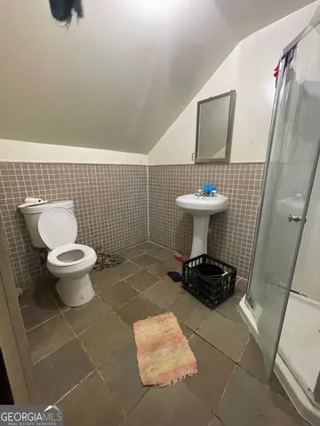 a bathroom with a toilet a sink and a mirror