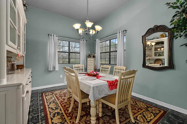 a dining room with furniture a chandelier and window