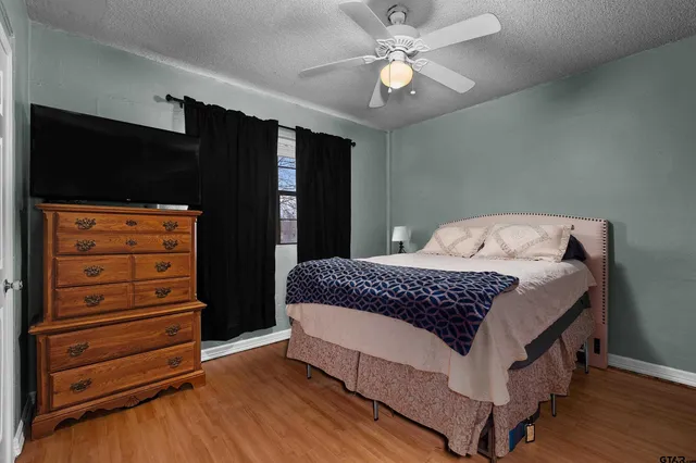 a bedroom with a bed and wooden floor