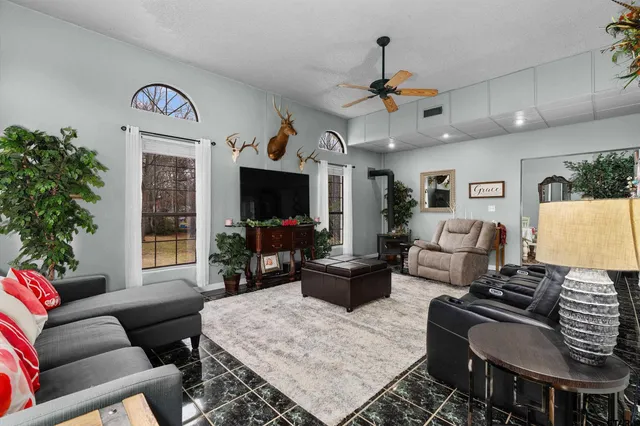 a living room with furniture a chandelier and a flat screen tv