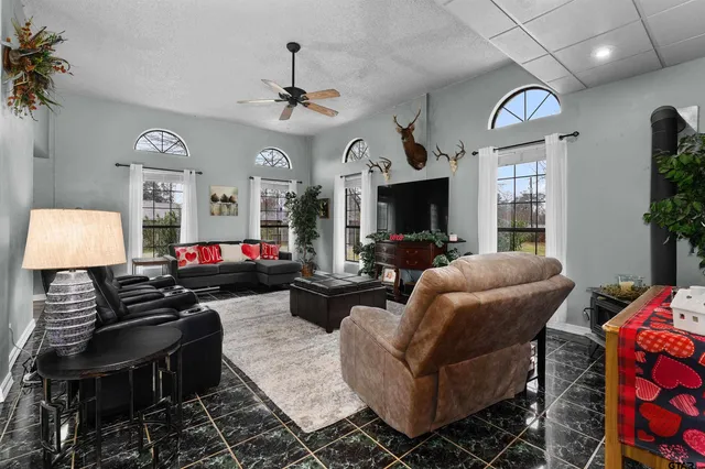 a living room with furniture a chandelier and a flat screen tv