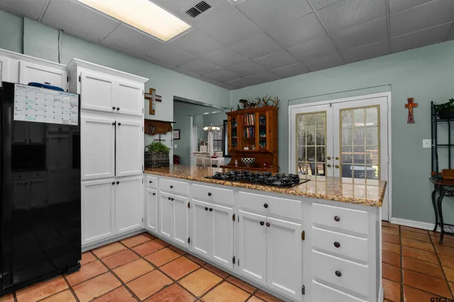 a kitchen with white cabinets and sink