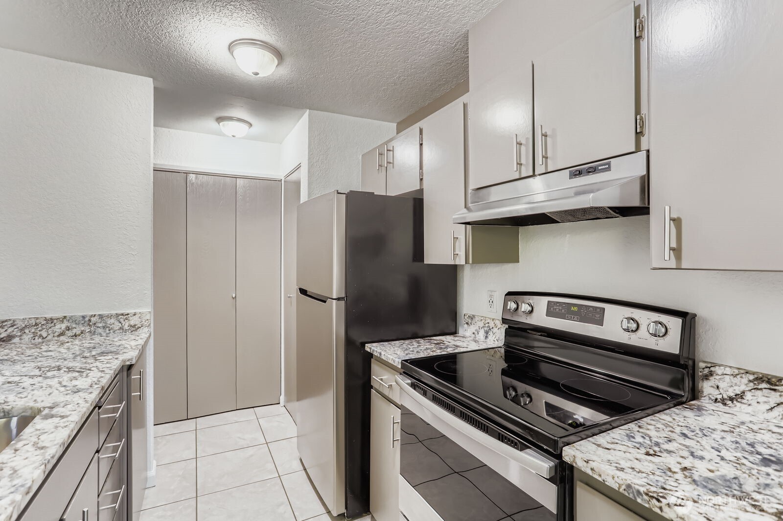 830 Kirkland Way, Unit 204 Kirkland, WA 98033 - Photo 12 of 27 a kitchen with a stove and a refrigerator