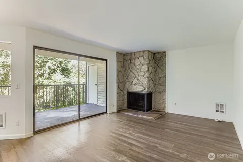 a view of empty room with wooden floor and fireplace