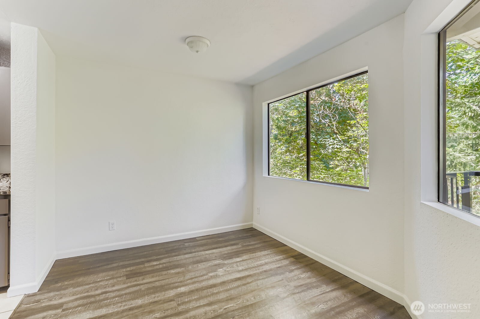 830 Kirkland Way, Unit 204 Kirkland, WA 98033 - Photo 7 of 27 a view of an empty room with wooden floor and a window