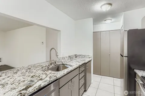 a kitchen with stainless steel appliances granite countertop a sink refrigerator and cabinets