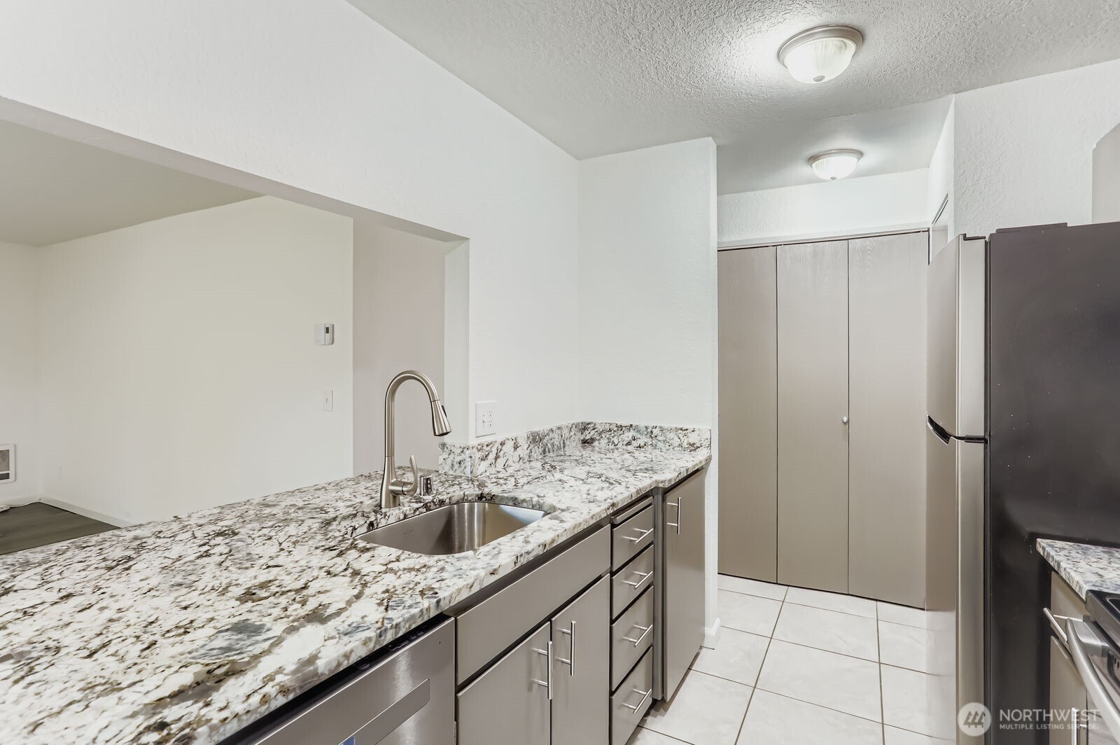 830 Kirkland Way, Unit 204 Kirkland, WA 98033 - Photo 10 of 27 a kitchen with stainless steel appliances granite countertop a sink refrigerator and cabinets