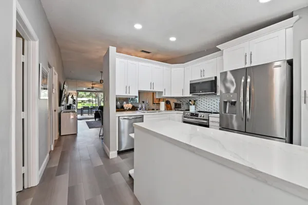 a kitchen with white cabinets and stainless steel appliances