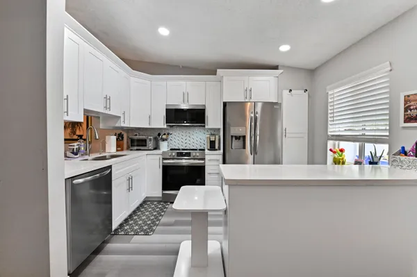 a kitchen with stainless steel appliances a refrigerator sink and microwave