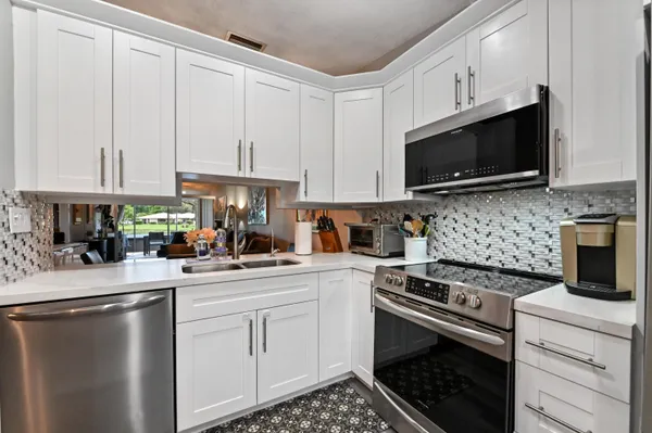 a kitchen with granite countertop a sink a stove and cabinets