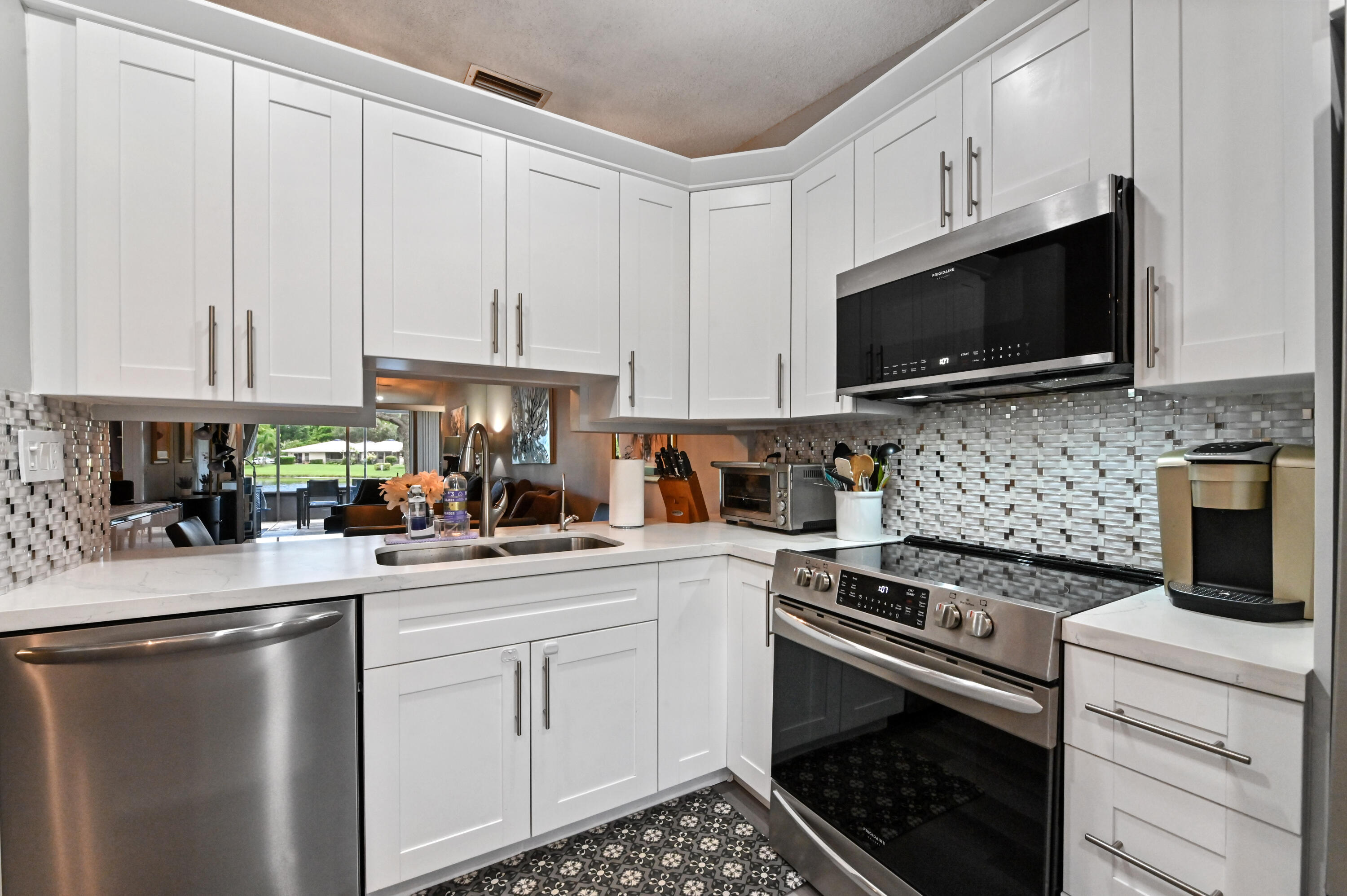 18824 Argosy Drive, Unit C Boca Raton, FL 33496 - Photo 5 of 18 a kitchen with granite countertop a sink a stove and cabinets