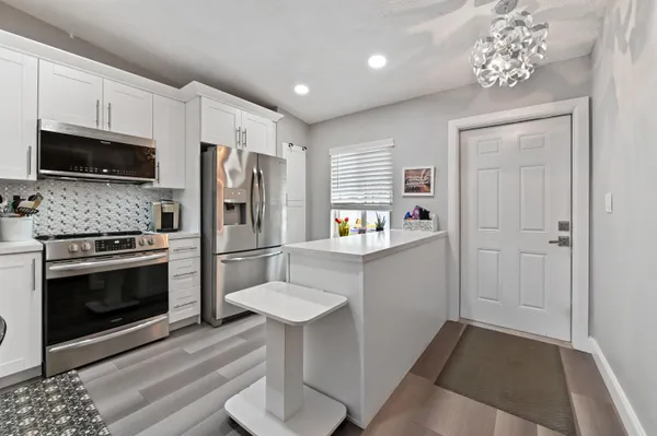 a kitchen with stainless steel appliances a refrigerator stove and microwave