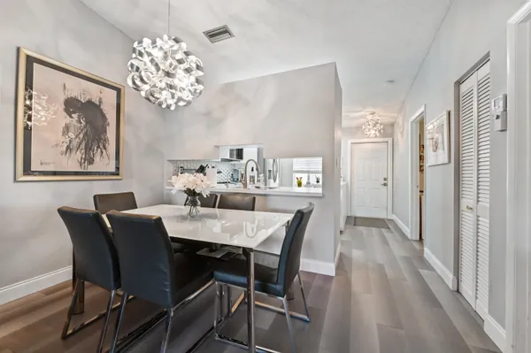 a view of a dining room with furniture a chandelier and wooden floor