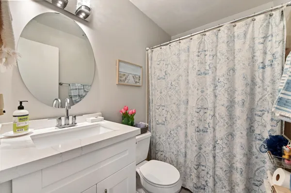 a bathroom with a sink a toilet and a mirror