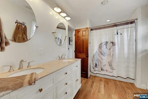 a bathroom with a granite countertop sink toilet and mirror