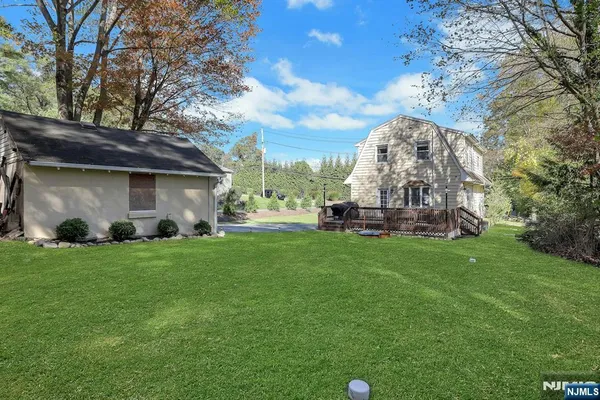a view of a house with a yard and large tree