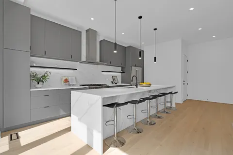 a close view of sink a stove and cabinets