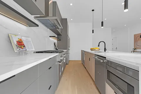 a kitchen with a sink a counter top space and stainless steel appliances