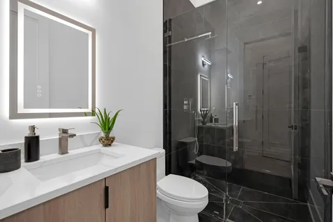 a bedroom with a bed a chair and painting on the wall