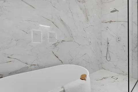 a bedroom with a bed a mirror and a lamp on dresser