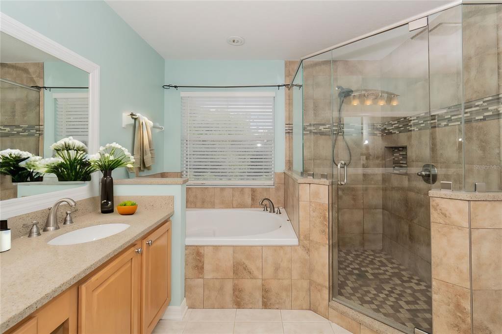 7018 Cascade Court Lakeland, FL 33813 - Photo 13 of 31 a bathroom with a granite countertop sink a shower and a mirror