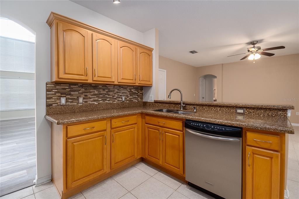 7018 Cascade Court Lakeland, FL 33813 - Photo 8 of 31 a kitchen with granite countertop cabinets stainless steel appliances a sink and a window