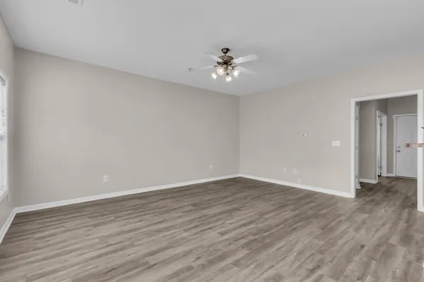 a view of an empty room with wooden floor