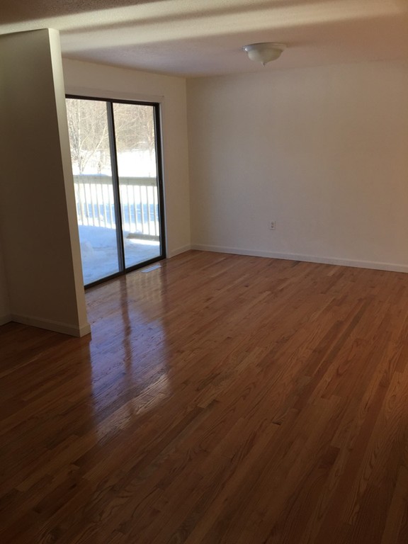 22 Winsor Road Billerica, MA 01821 - Photo 4 of 9 an empty room with wooden floor and windows