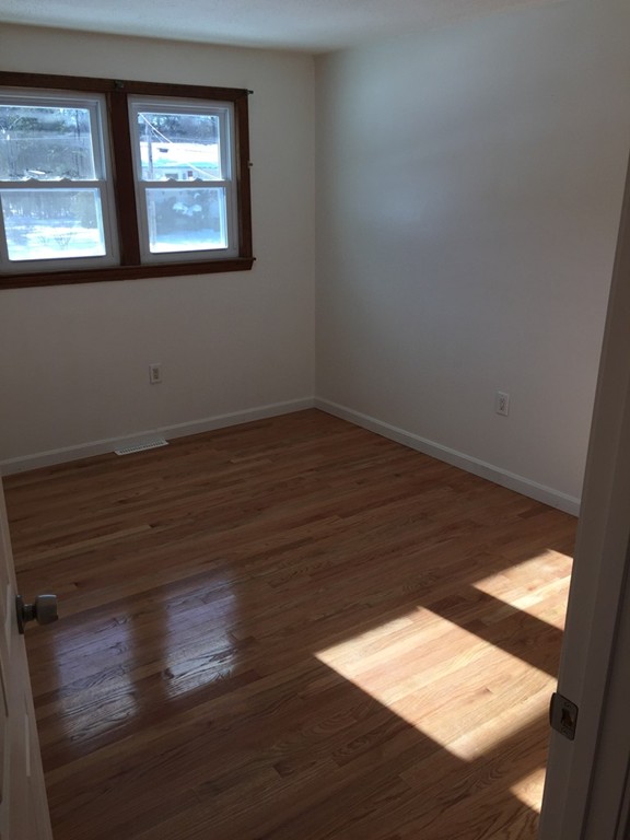22 Winsor Road Billerica, MA 01821 - Photo 7 of 9 a view of an empty room with wooden floor and a window