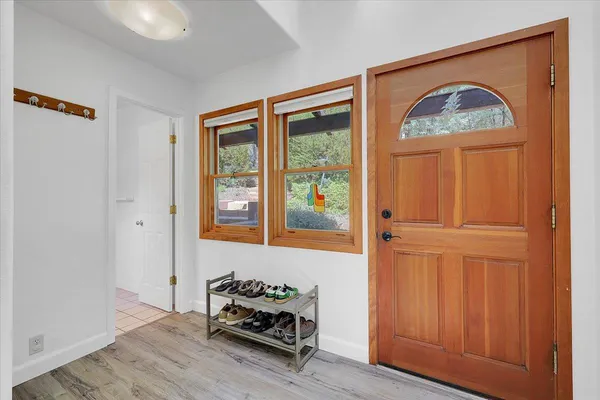 a bedroom with a bed and dresser with wooden floor