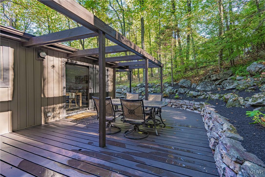 110 Mountain Park Road Allentown, PA 18103 - Photo 20 of 22 a view of a patio with table and chairs under an umbrella with wooden floor