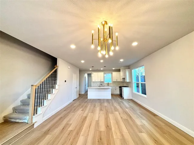 a view of a living room and chandelier with wooden floor