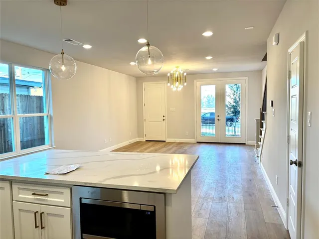 a view of a living room and kitchen with wooden floor