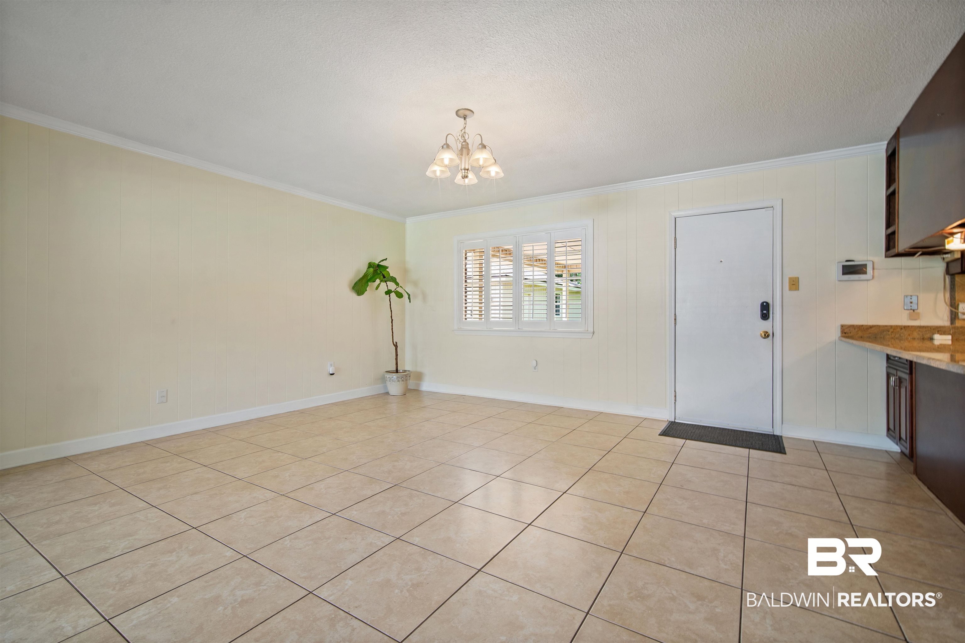 1325 Pawnee Circle Saraland, AL 36571 - Photo 6 of 26 Unfurnished dining area featuring crown molding, a chandelier, and light tile patterned floors