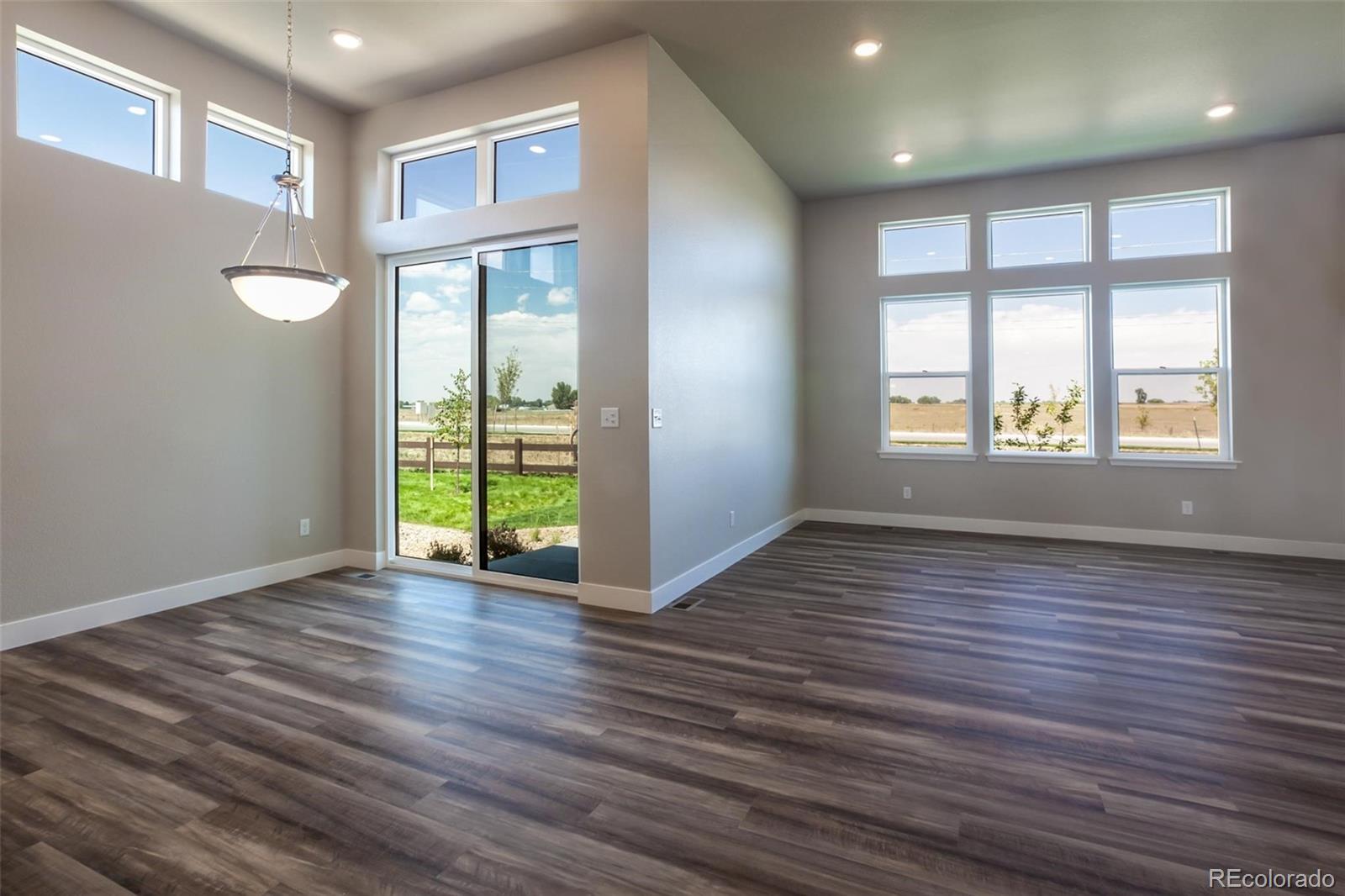 6768 Castello Street Timnath, CO 80547 - Photo 15 of 38 a view of an empty room with wooden floor and a window