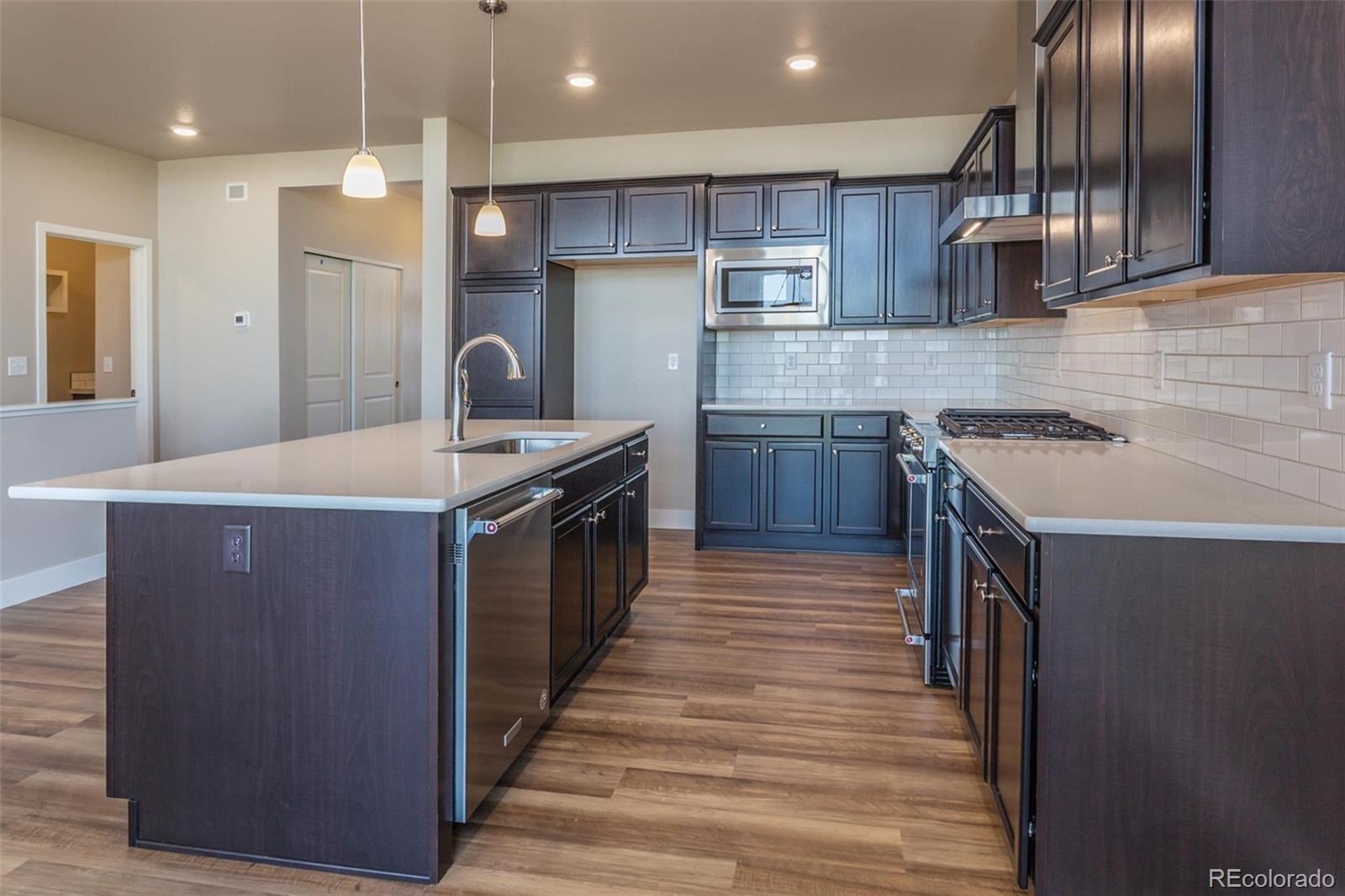 6768 Castello Street Timnath, CO 80547 - Photo 16 of 38 a kitchen with stainless steel appliances granite countertop a stove a sink and a refrigerator