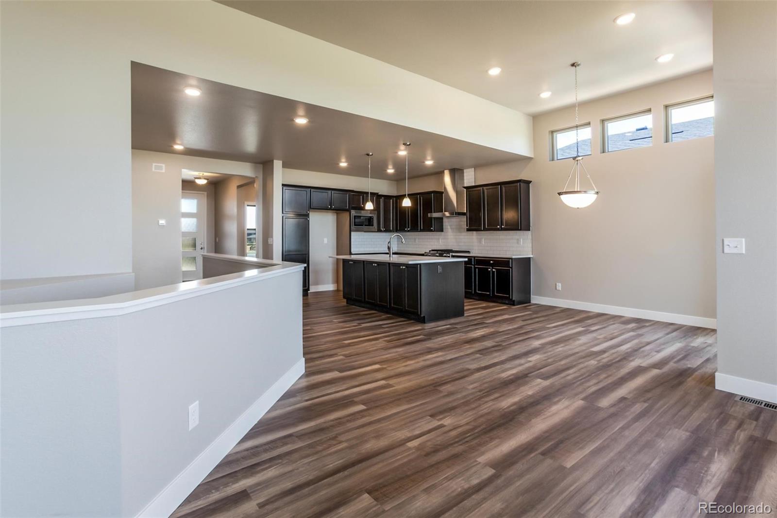 6768 Castello Street Timnath, CO 80547 - Photo 19 of 38 a large white kitchen with a large counter top appliances and cabinets