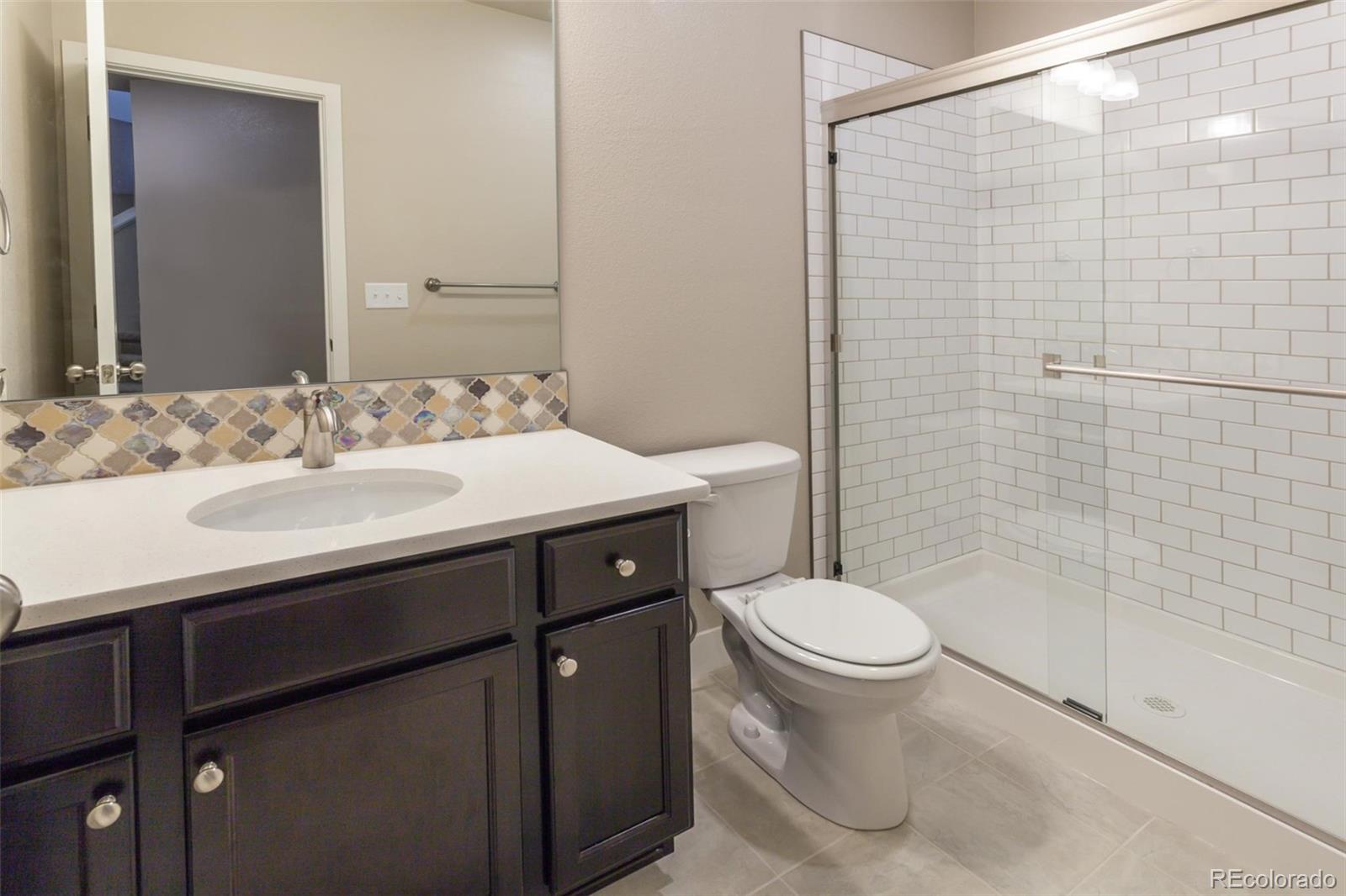 6768 Castello Street Timnath, CO 80547 - Photo 26 of 38 a bathroom with a sink toilet and shower