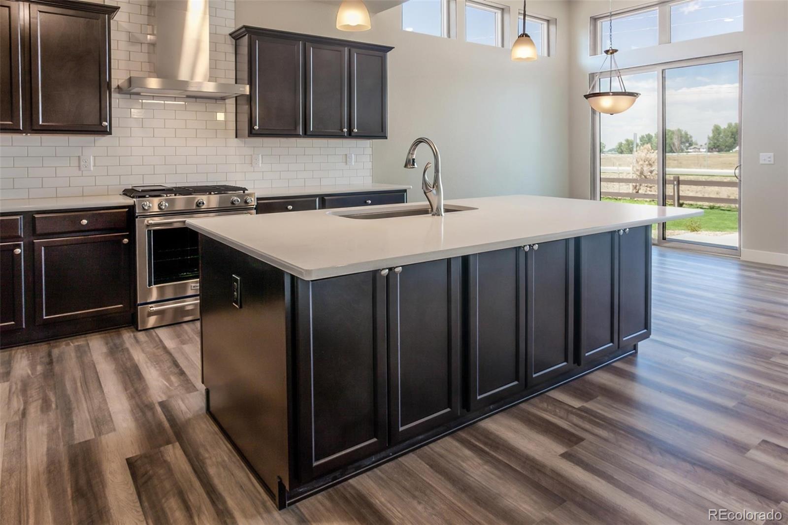 6768 Castello Street Timnath, CO 80547 - Photo 33 of 38 a kitchen with a sink stove and cabinets