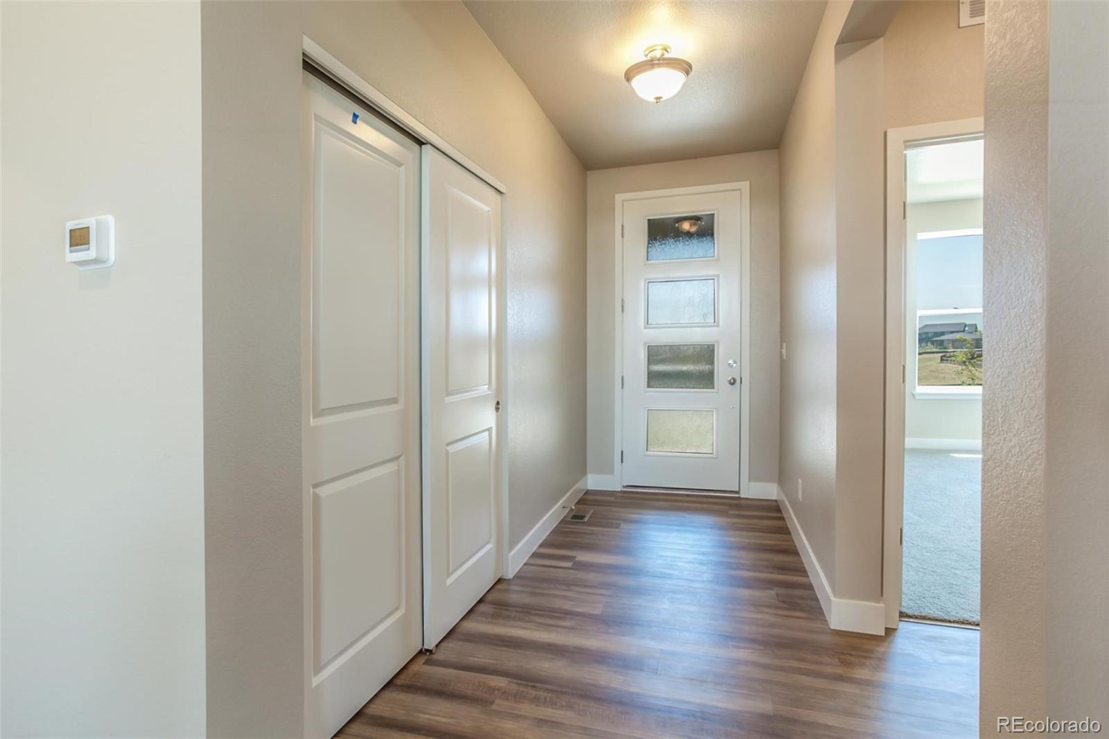 6768 Castello Street Timnath, CO 80547 - Photo 35 of 38 a view of a hallway with wooden floor