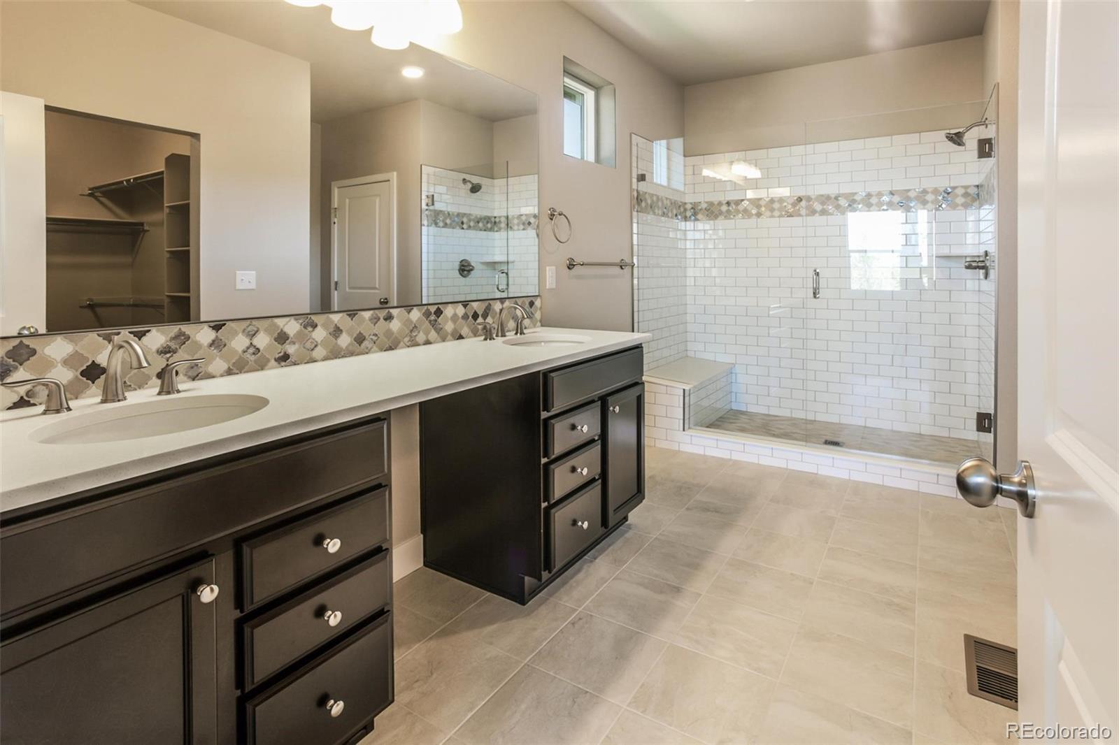 6768 Castello Street Timnath, CO 80547 - Photo 38 of 38 a bathroom with a double vanity sink mirror double and shower