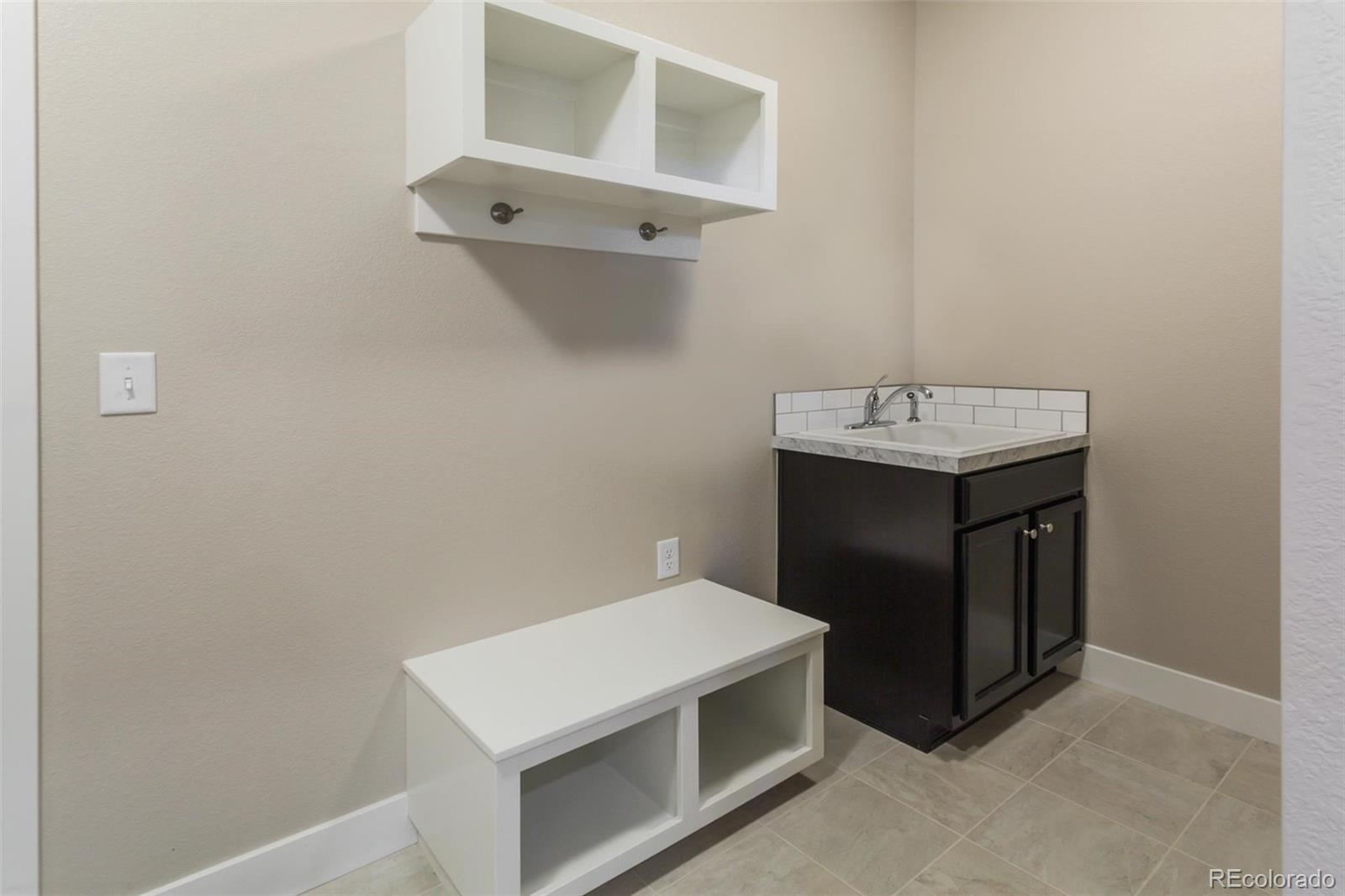 6768 Castello Street Timnath, CO 80547 - Photo 7 of 38 a utility room with cabinets